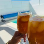 Close de duas taças com drinks à beira da piscina privativa na casa de praia em porto covo.